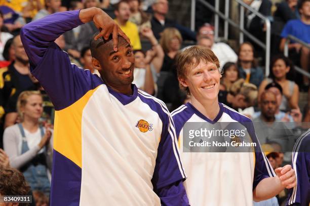 Kobe Bryant and Coby Karl of the Los Angeles Lakers joke around with teammates from the sideline during the preseason game against the Toronto...