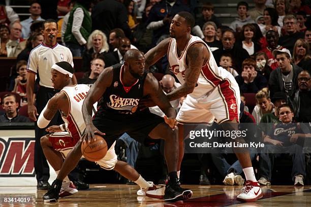 Reggie Evans of the Philadelphia 76ers moves the ball against Lorenzen Wright of the Cleveland Cavaliers during the game at Quicken Loans Arena on...