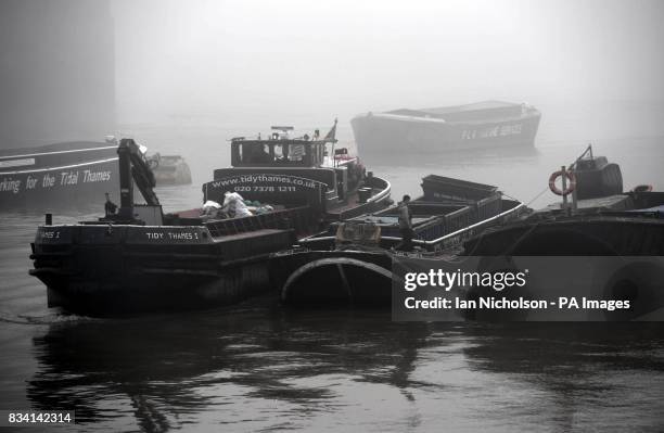 River boatman works on the Thames, near the South Bank in the early morning fog.