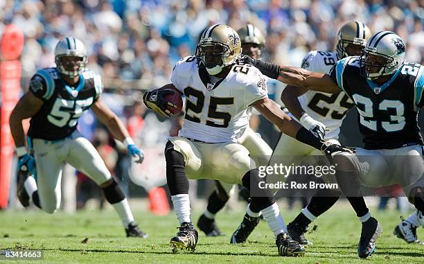 Dante Wesley of the Carolina Panthers tackles Reggie Bush of the New Orleans Saints during the first half at Bank of America Stadium on October 19,...