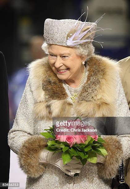 Queen Elizabeth II laughs after throwing in the puck to start an ice hockey match between Aqua City Poprad and Guildford Flames at the ice hockey...