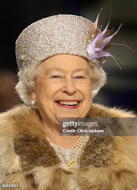 Queen Elizabeth II laughs after throwing in the puck to start an ice hockey match between Aqua City Poprad and Guildford Flames at the ice hockey...