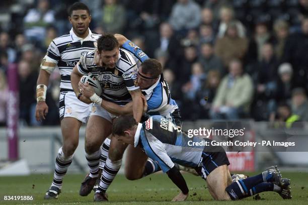Hull FC's Tommy Lee is tackled by Harlequins' Rob Purdham and Danny Orr