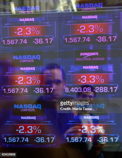 Men walk past the Nasdaq MartketSite tickers in Times Square October 24, 2007 in New York City. Stocks were down in afternoon trading on fears of of...