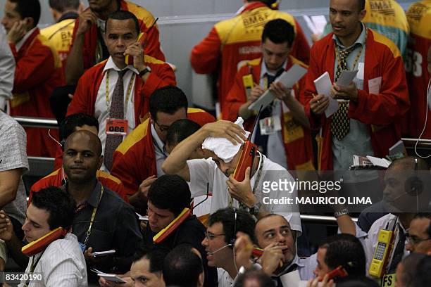 Stock trader wipes the sweat from his head while negotiating in the iBovespa future index pit, at the Mercantile & Futures Exchange in Sao Paulo,...