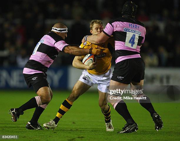 Josh Lewsey of Wasps is sandwiched by Andy Long and Andy Perry of Newcastle Falcond during the EDF Energy Cup match between Newcastle Falcons and...