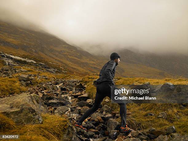 man running up mountain - endurance run stock pictures, royalty-free photos & images