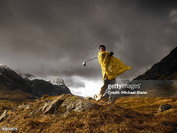 man playing golf on mountain in rain - out of context foto e immagini stock
