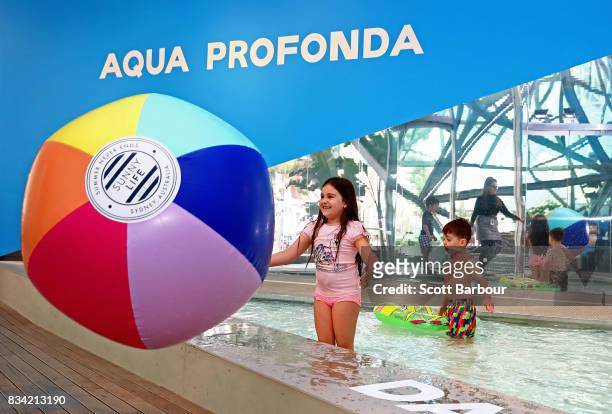 Children play with a beach ball as they play in a 11 metre long swimming pool to celebrate the Australian premiere of The Pool exhibition at the...
