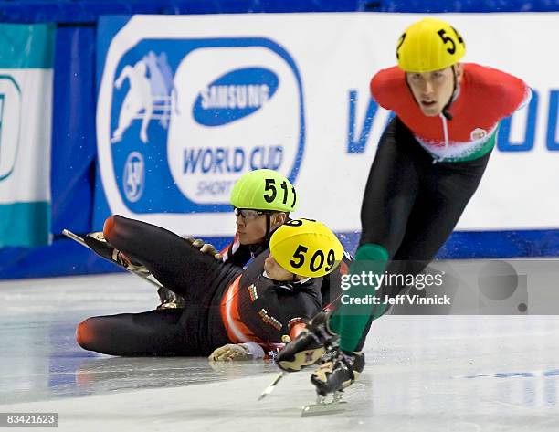 Peter Daraz of Hungary turns a corner as Viktor Dimitrov of Bulgaria and Francois Hamelin of Canada crash into the ice during their 1000m heat at the...