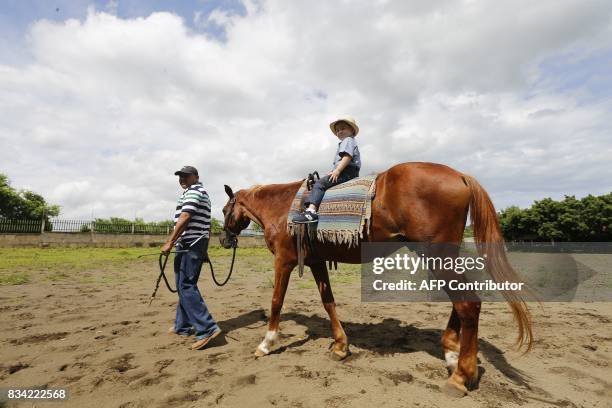 Four-year-old Giancarlo Carrillo, rides a horse during his hippotherapy session at the private center "Centro Equestre Aras del Carmen", in the rural...