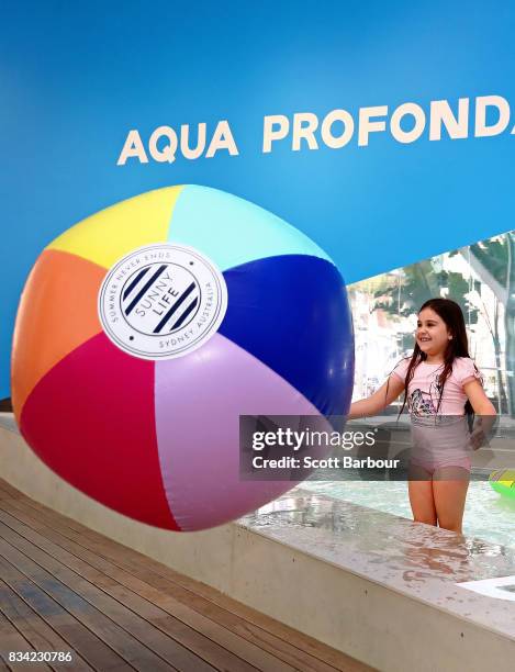 Children play with a beach ball as they play in a 11 metre long swimming pool to celebrate the Australian premiere of The Pool exhibition at the...