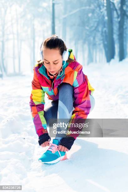 young woman tying his shoelace - running spikes stock pictures, royalty-free photos & images
