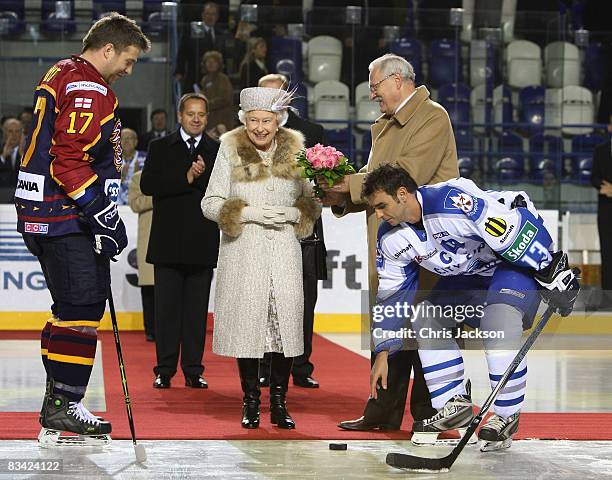 Queen Elizabeth II is handed a puck by President of Slovakia Ivan Gasparovic before throwing in the puck to start an ice hockey match between Aqua...