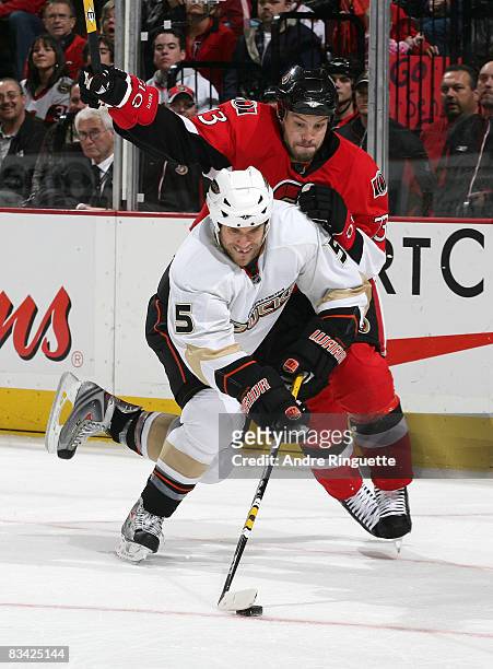 Steve Montador of the Anaheim Ducks stickhandles the puck as Jarkko Ruutu of the Ottawa Senators battles for position at Scotiabank Place on October...