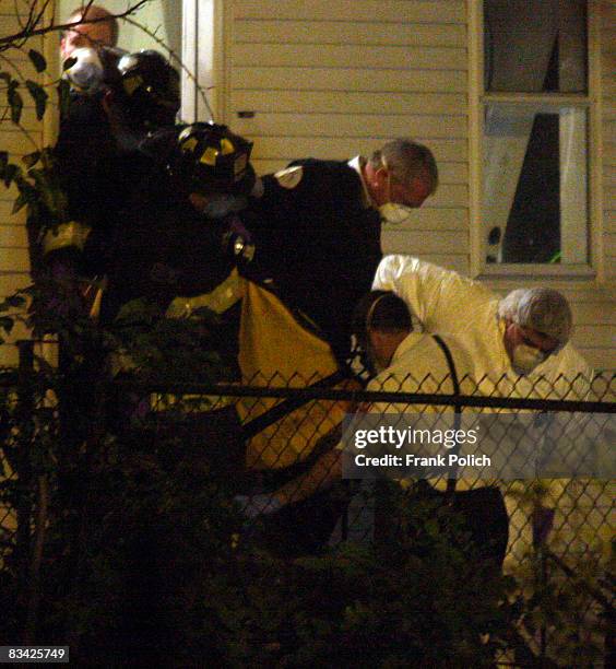 Police police remove a body from a home in the Englewood neighborhood where 57-year-old Darnell Hudson Donerson, the mother of Oscar winner Jennifer...