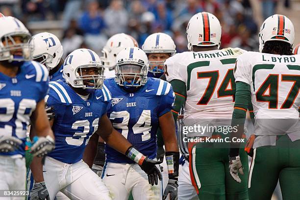 Vincent Rey and Micheal Tauiliili of the Duke Blue Devils confront Orlando Franklin of the Miami Hurricanes at Wallace Wade Stadium on October 18,...