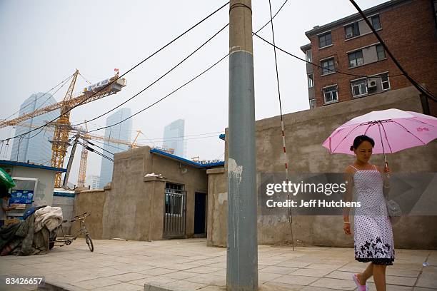 People walk in front of a construction site dotted with cranes in another newly developing construction project in the rapidly developing city on...