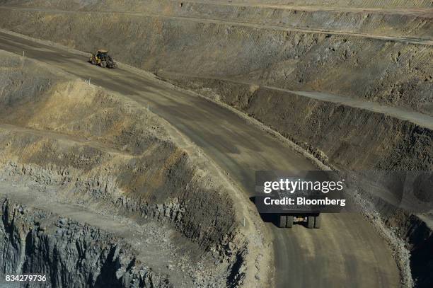 Dump truck, bottom, drives along an access ramp in the White Foil open mine pit at Evolution Mining Ltd.'s gold operations in Mungari, Australia, on...