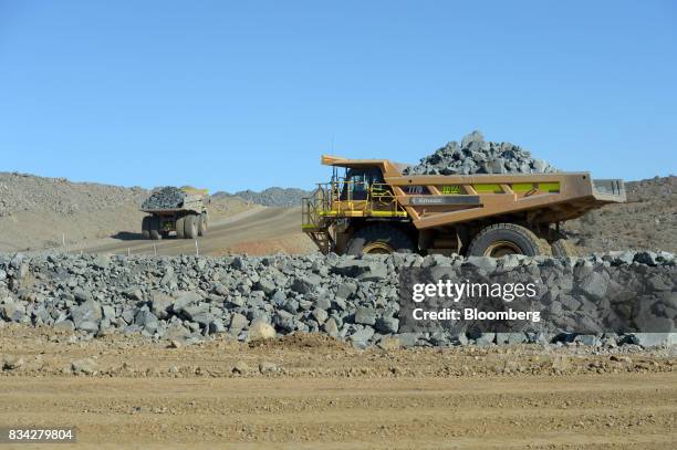 Dump trucks filled with ore drive out of in the White Foil open mine pit at Evolution Mining Ltd.'s gold operations in Mungari, Australia, on...