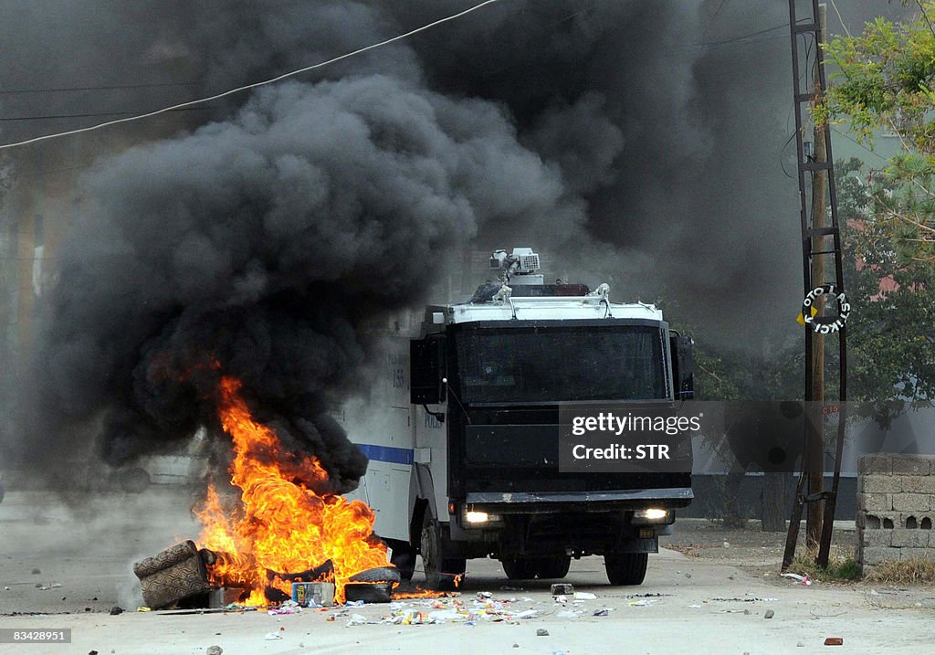 A truck of the Turkish riot police passes a barricade during clashes ...