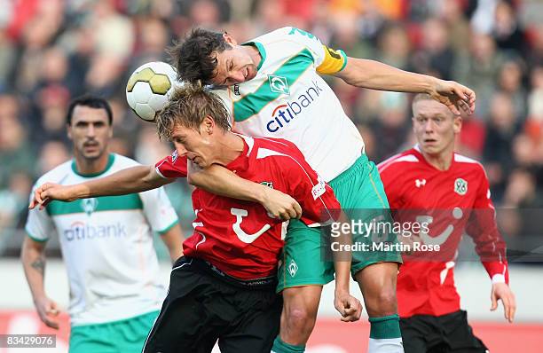 Frank Fahrenhorst of Hannover 96 and Frank Baumann Bremen head for the ball during the Bundesliga match between Hannover 96 and Werder Bremen at the...