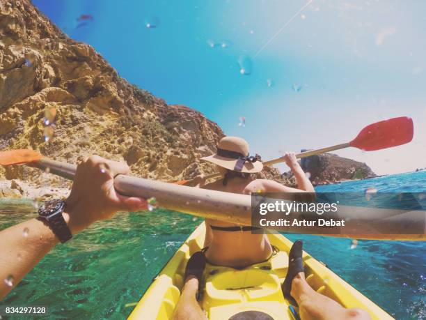 couple doing kayak taking picture from boyfriend personal perspective exploring the natural medes islands in the shoreline of costa brava mediterranean sea during summer vacations in a paradise place. - summer kayaking stockfoto's en -beelden