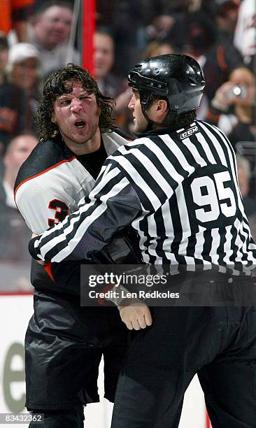 Riley Cote of the Philadelphia Flyers is restrained by Linesman Jonny Murray after a fight against the New Jersey Devils on October 25, 2008 at the...