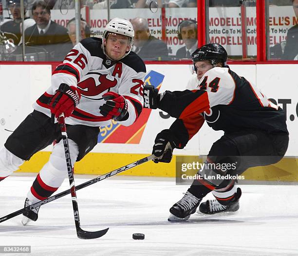 Patrick Elias of the New Jersey Devils dekes around Kimmo Timonen of the Philadelphia Flyers on October 25, 2008 at the Wachovia Center in...