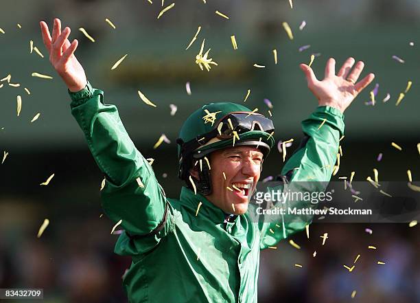 Jockey Lanfranco Dettori celebrates with flower petals atop Raven's Pass after winning the Breeders' Cup Classic during the Breeders' Cup World...