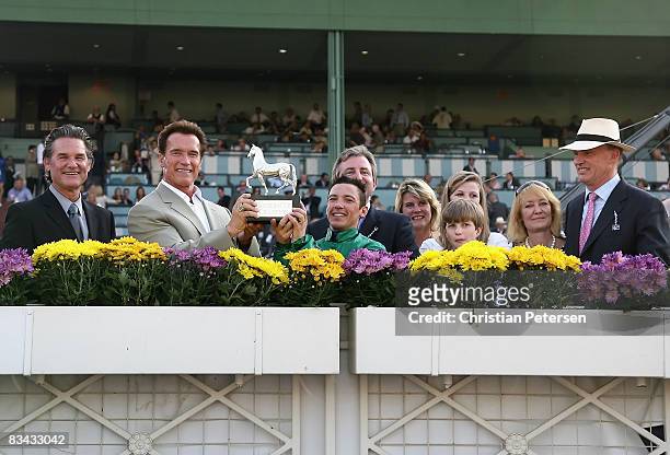 Actor Kurt Russell, Governor Arnold Schwarzenegger, jockey Frankie Dettori, riding Raven?s Pass , and trainer John Gosden pose with the Breeder's Cup...