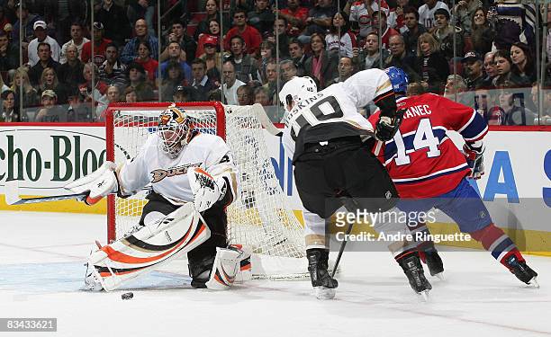 Jean-Sebastien Giguere of the Anaheim Ducks makes a pad save as Kent Huskins of the Anaheim Ducks defends against Tomas Plekanec of the Montreal...