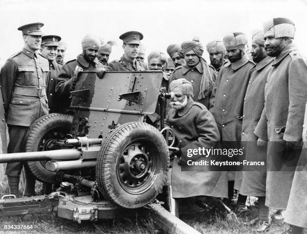 Les soldats indiens regardent avec beaucoup d'intérêt le canon antichar présenté sur la base militaire de Pirbright, Royaume-Uni en mai 1937.