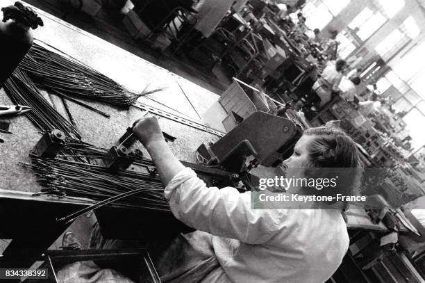 Ouvrière au travail dans l'atelier de fabrication de téléviseurs à Nogent-le-Rotrou, France en juillet 1967.