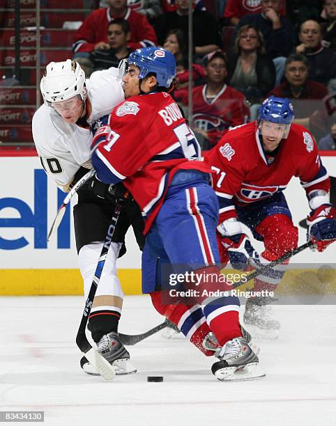 Francis Bouillon of the Montreal Canadiens bodychecks Corey Perry of the Anaheim Ducks off the puck at the Bell Centre on October 25, 2008 in...