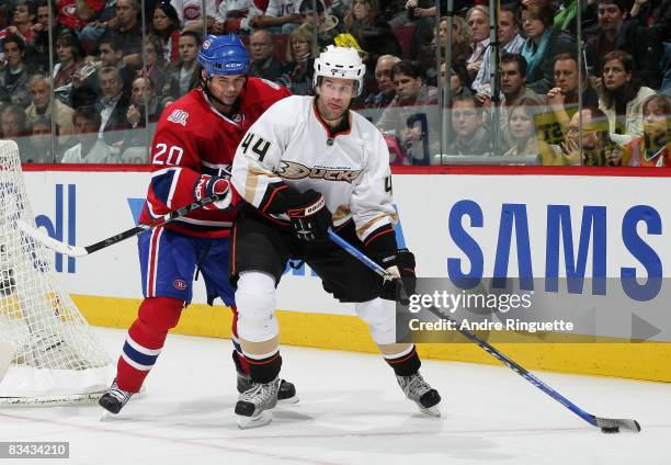 Rob Niedermayer of the Anaheim Ducks looks to pass as Robert Lang of the Montreal Canadiens checks at the Bell Centre on October 25, 2008 in...