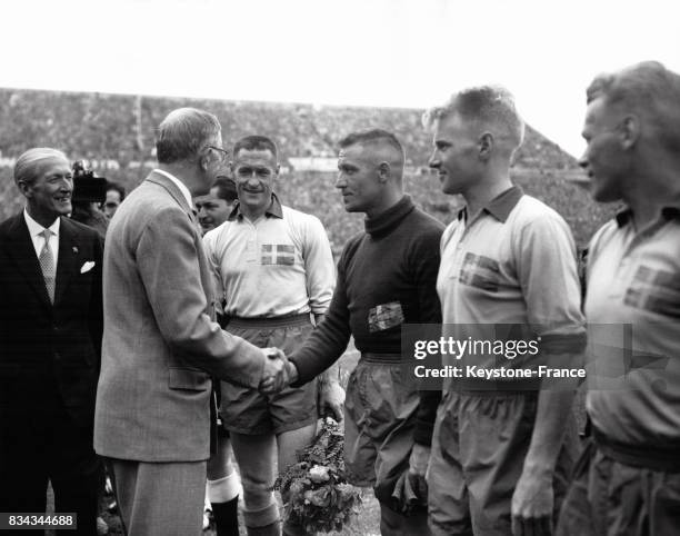 Avant la finale opposant la Suède au Brésil, le roi Gustave-Adolphe de Suède serre la main de Kalle Svensson, le gardien de but de l'équipe, à Solna,...