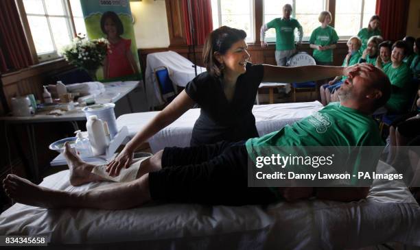 Beauty therapist Susanne Baird waxing the legs of comic Fred MacAulay during her world record leg waxing attempt in Edinburgh.