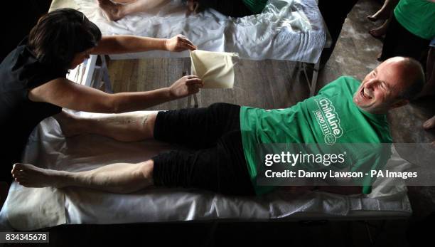 Beauty therapist Susanne Baird waxing the legs of comic Fred MacAulay during her world record leg waxing attempt in Edinburgh.