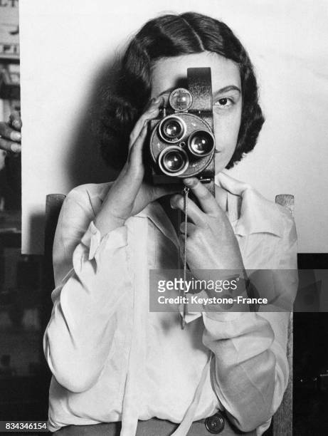 Une jeune fille présente la dernière caméra de la marque Cinématographe présentée au salon de la photographie à Londres, Royaume-Uni en septembre...