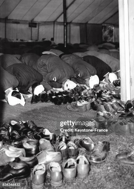 Dans une mosquée, les hommes prient et le chaussures sont laissées à l'extérieur du lieu de culte, à Londres, Royaum-Uni le 12 septembre 1951.