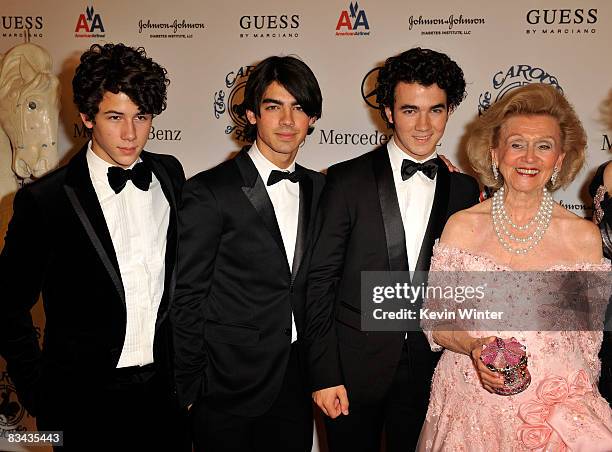 Musicians Nick Jonas, Joe Jonas, Kevin Jonas of The Jonas Brothers and Barbara Davis pose during the cocktail reception at the 30th anniversary...