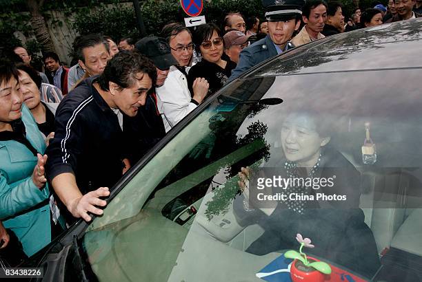 Director Wang Fuli gestures in a sedan as she is surrounded by people after attending the funeral of the famed Chinese film director Xie Jin at the...