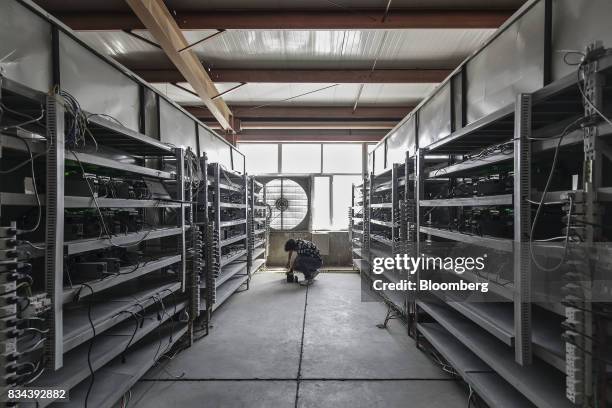 Technician inspects bitcoin mining machines at a mining facility operated by Bitmain Technologies Ltd. In Ordos, Inner Mongolia, China, on Friday,...