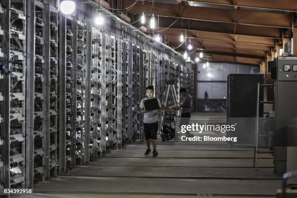 Technicians inspect bitcoin mining machines at a mining facility operated by Bitmain Technologies Ltd. In Ordos, Inner Mongolia, China, on Friday,...