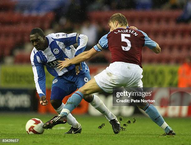 Emile Heskey of Wigan Athletic attempts to move past Martin Laursen of Aston Villa during the FA Barclays Premier League match between Wigan Athletic...