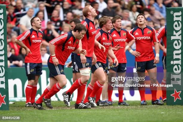 The Munster players wait under the posts as they watch a penalty go over