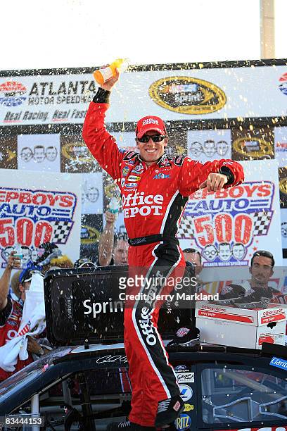 Carl Edwards driver of the Ofice Depot Ford celebrates in Victory Lane after winning the NASCAR Sprint Cup Series Pep Boys Auto 500 at Atlanta Motor...