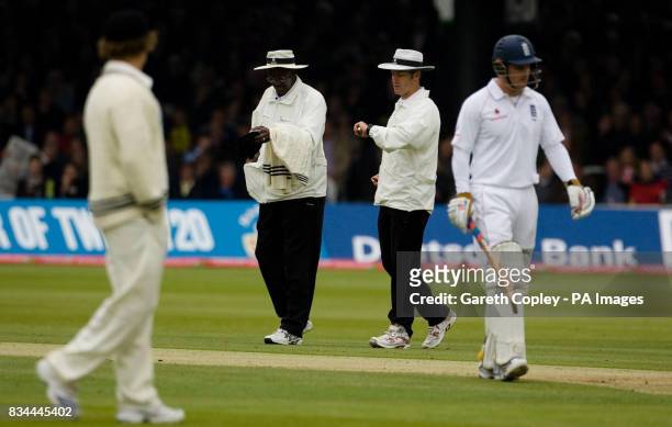 Umpires Steve Bucknor and Simon Taufel take a light reading as England's Andrew Strauss and New Zealand's James Marshall leave the field when bad...