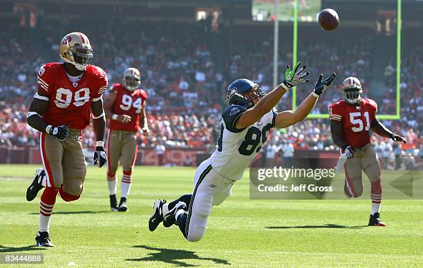 Tight end John Carlson of the Seattle Seahawks lunges but can't make a catch in front of Manny Lawson of the San Francisco 49ers in the first quarter...